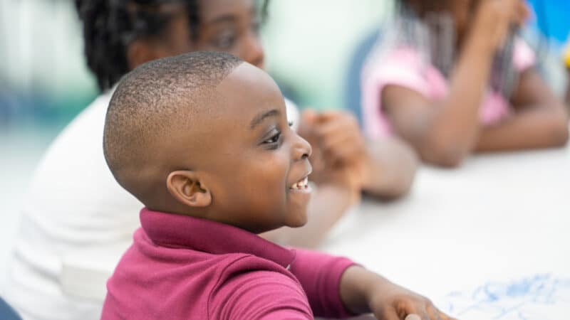 Young boy in a classroom smiling